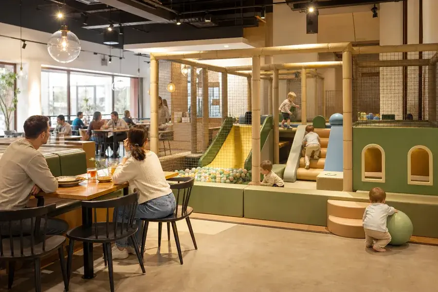 A family-friendly restaurant with a compact soft-play corner beside dining tables