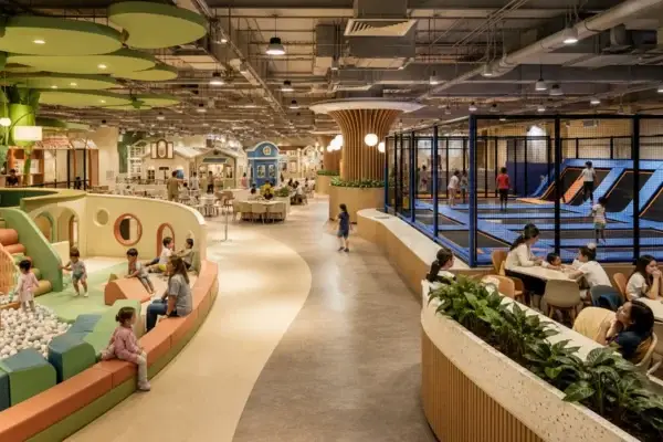 Modern family entertainment center combining a trampoline zone, toddler play, role play, cafe, and party rooms