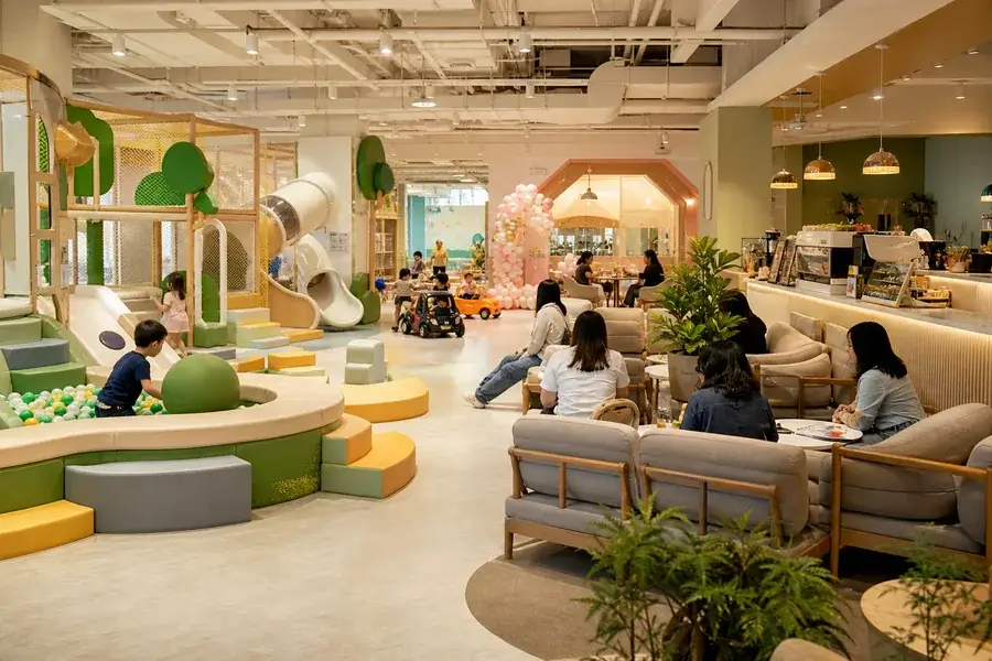 Commercial play cafe layout with parent seating and indoor playground zones for repeat family visits