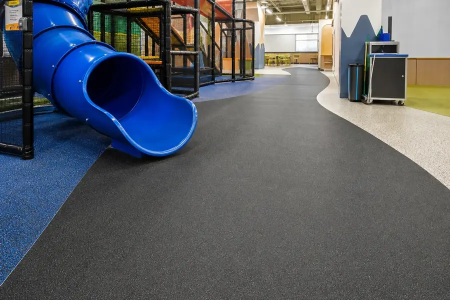 High-traffic indoor playground slide exit with durable rubber flooring
