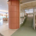 Commercial soft play structure with a PVC-covered padded column, slide, and cleanable landing pads.